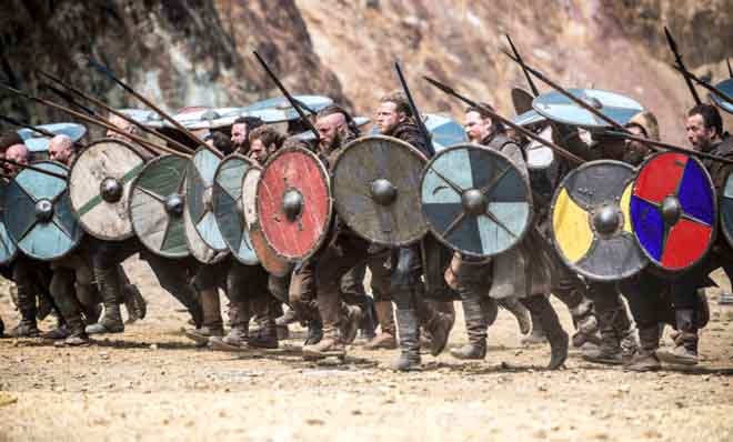 Una scena della carica dei vichinghi con gli scudi e le spade nella serie TV Vikings